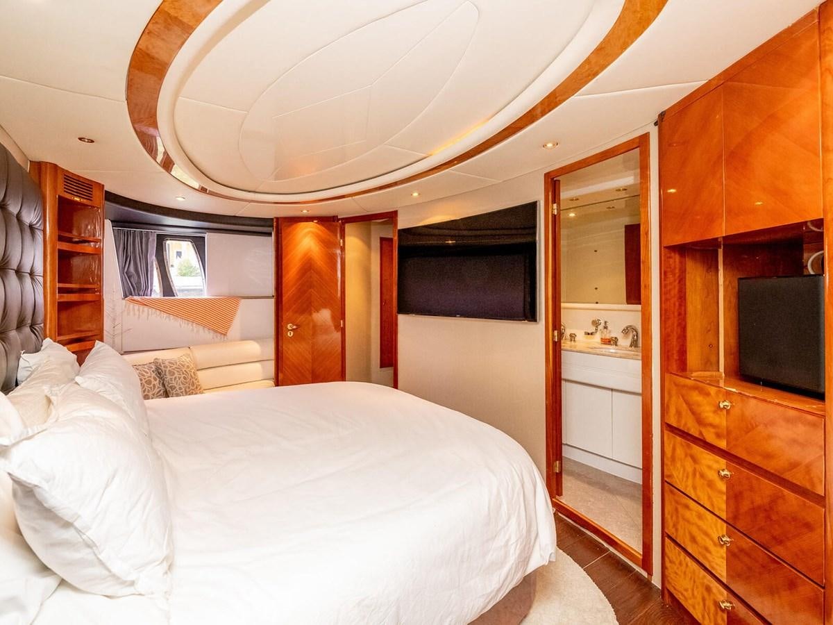 a bedroom with a bed and a television aboard NUEVA OLA Yacht for Sale