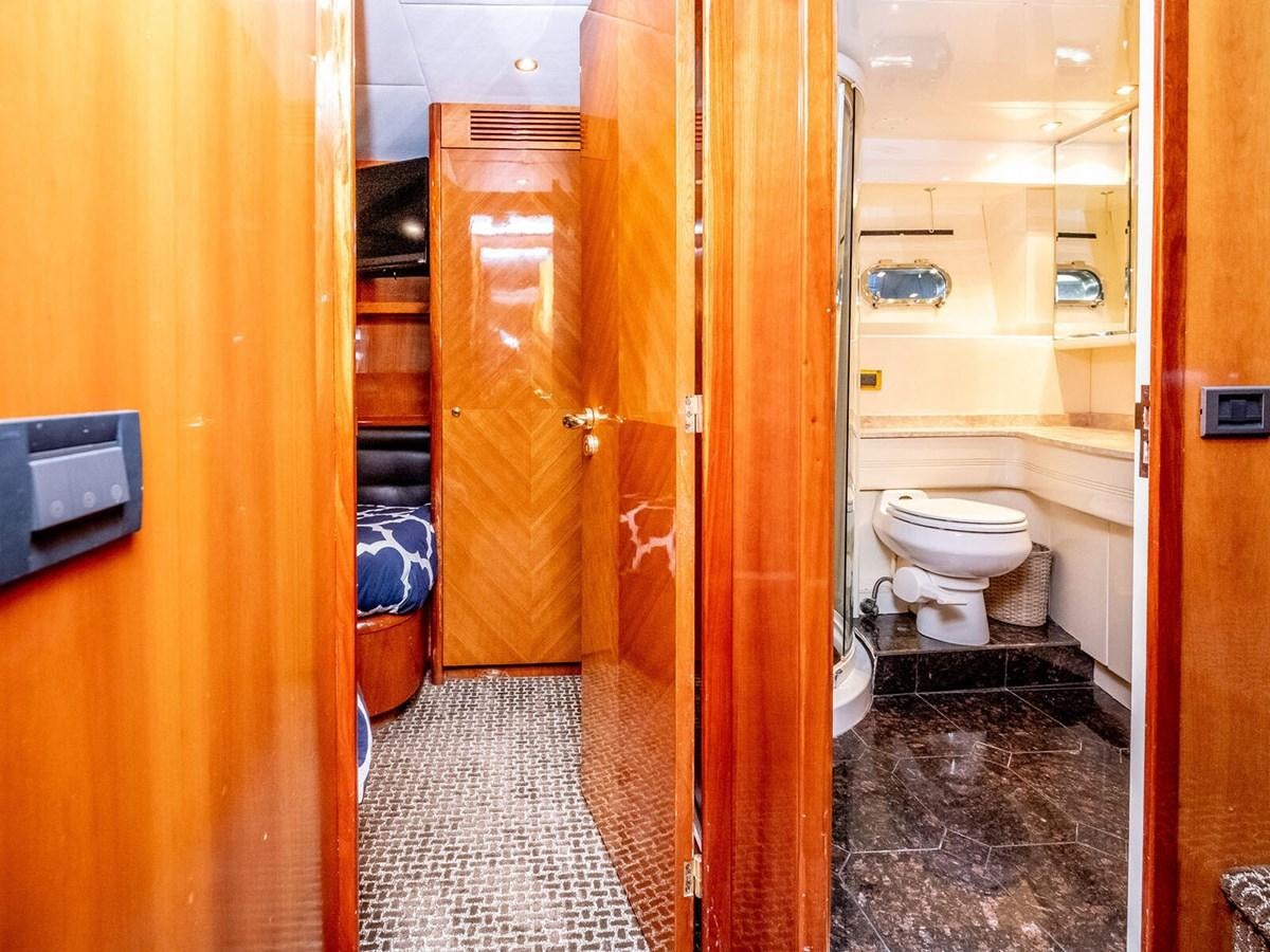 a bathroom with a toilet and a wooden door aboard NUEVA OLA Yacht for Sale