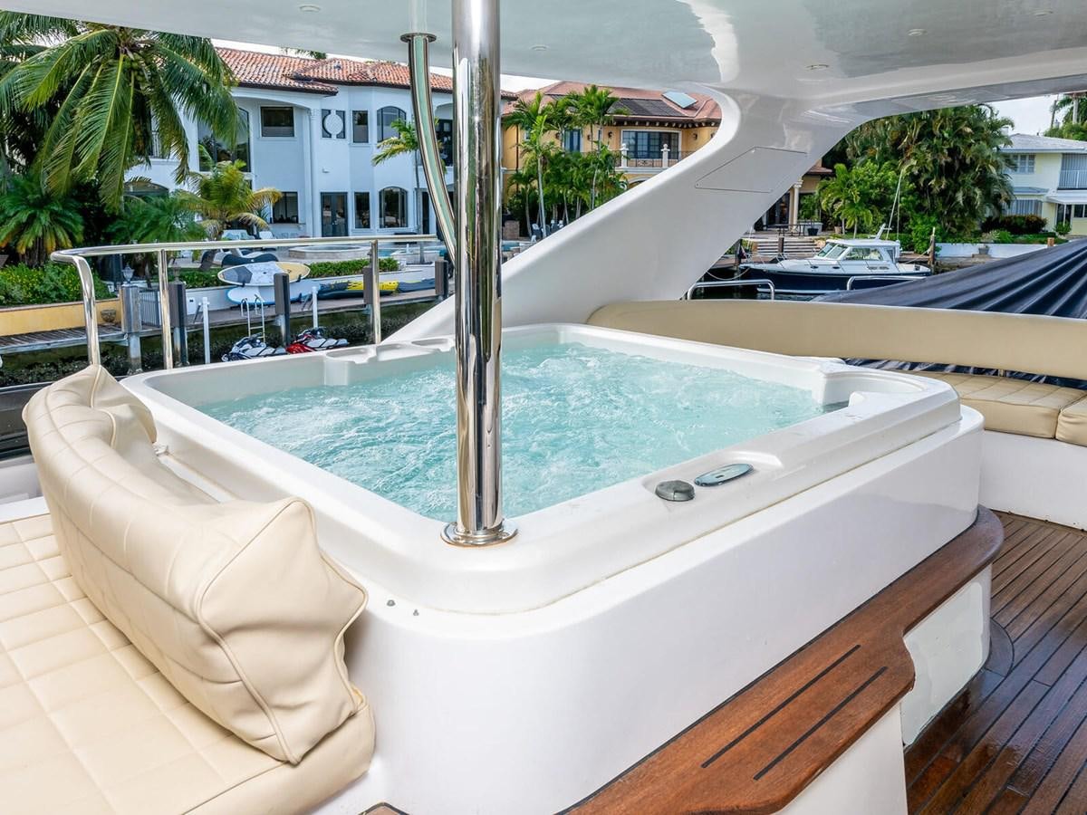 a pool with a deck and a building in the background aboard NUEVA OLA Yacht for Sale