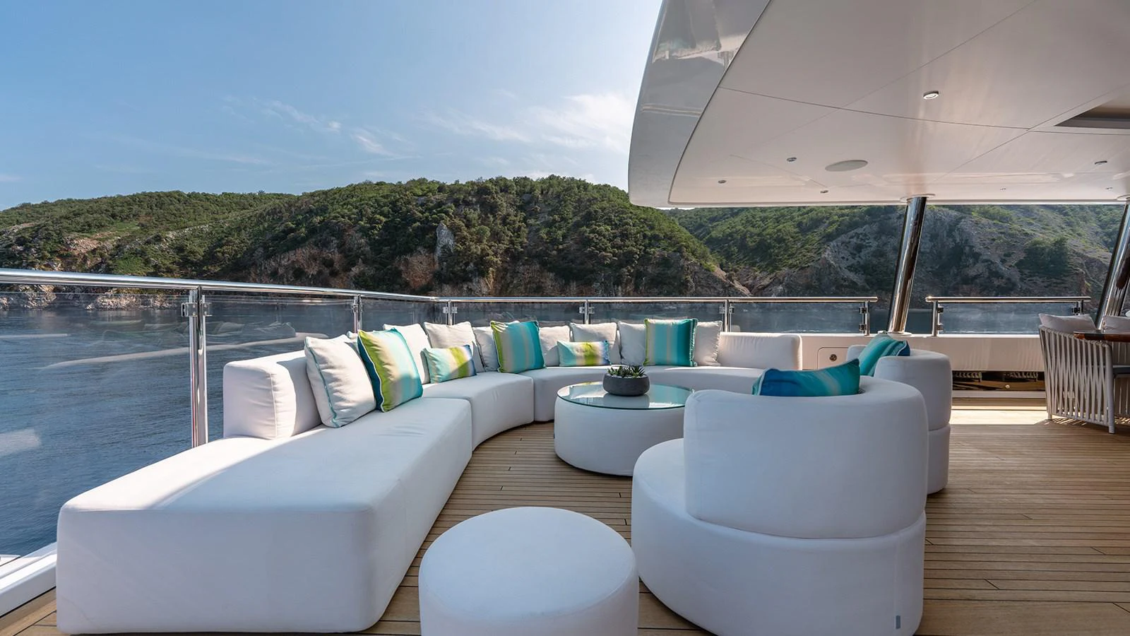 a large white couch with a blue pillow on a wooden deck aboard SEAGULL MRD Yacht for Sale