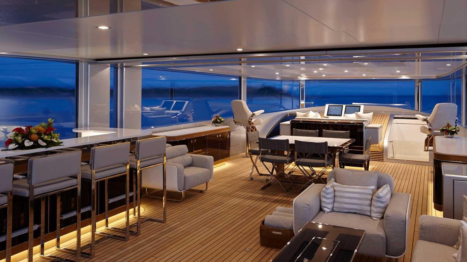 a room with a couch and a table and chairs aboard EXCELLENCE V Yacht for Sale
