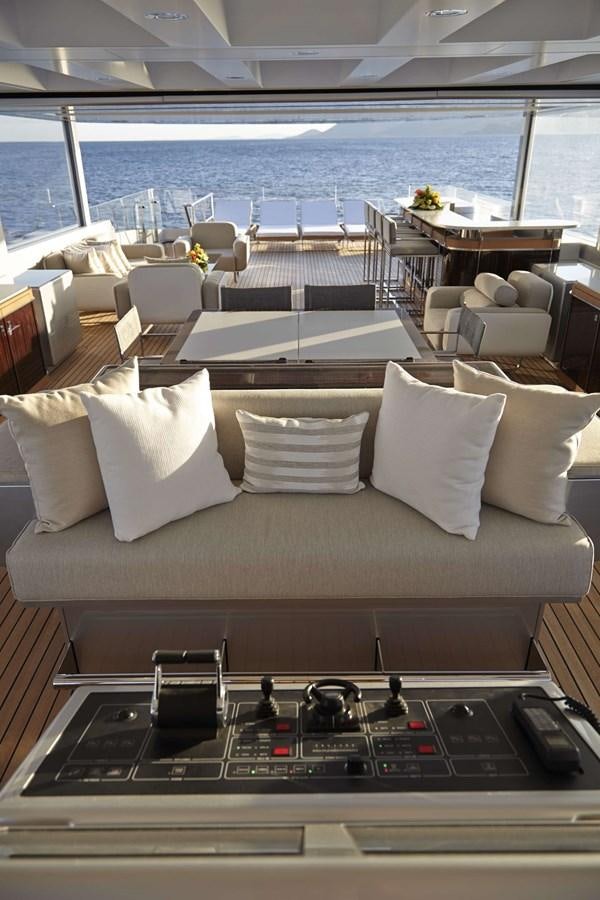 a couch with pillows and a table in a room with a large body of water aboard EXCELLENCE V Yacht for Sale