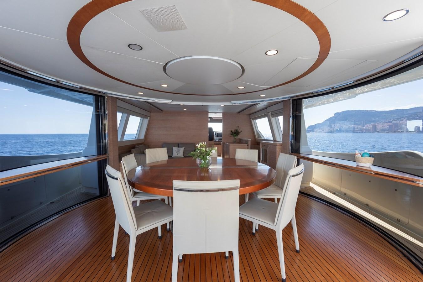 a dining table and chairs in a room with a large window aboard CENTURION Yacht for Sale