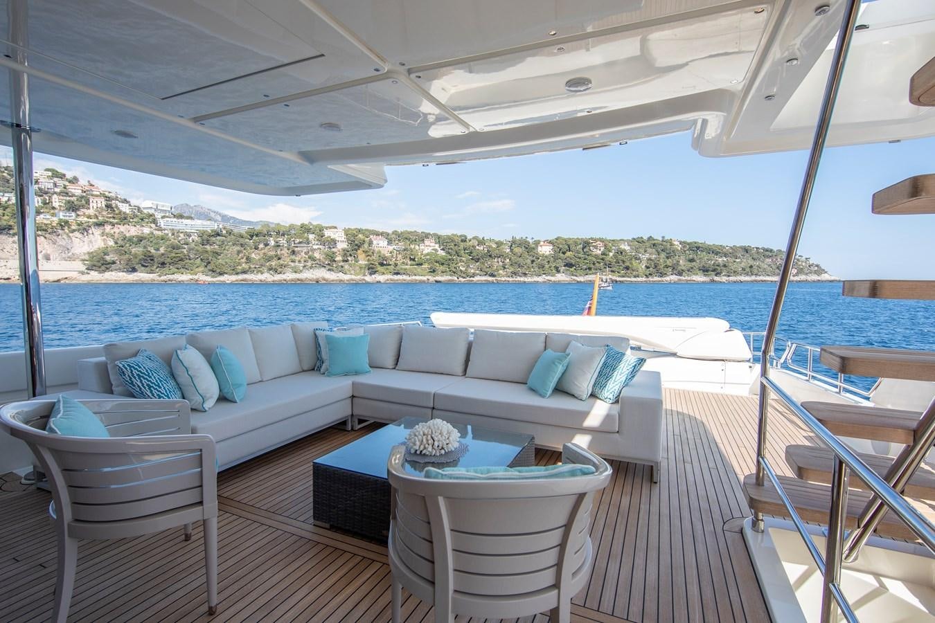 a large white lounge chair on a deck overlooking a large body of water aboard CENTURION Yacht for Sale