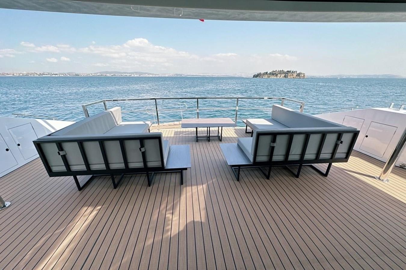 a deck with chairs and a body of water in the background aboard CARBO Yacht for Sale