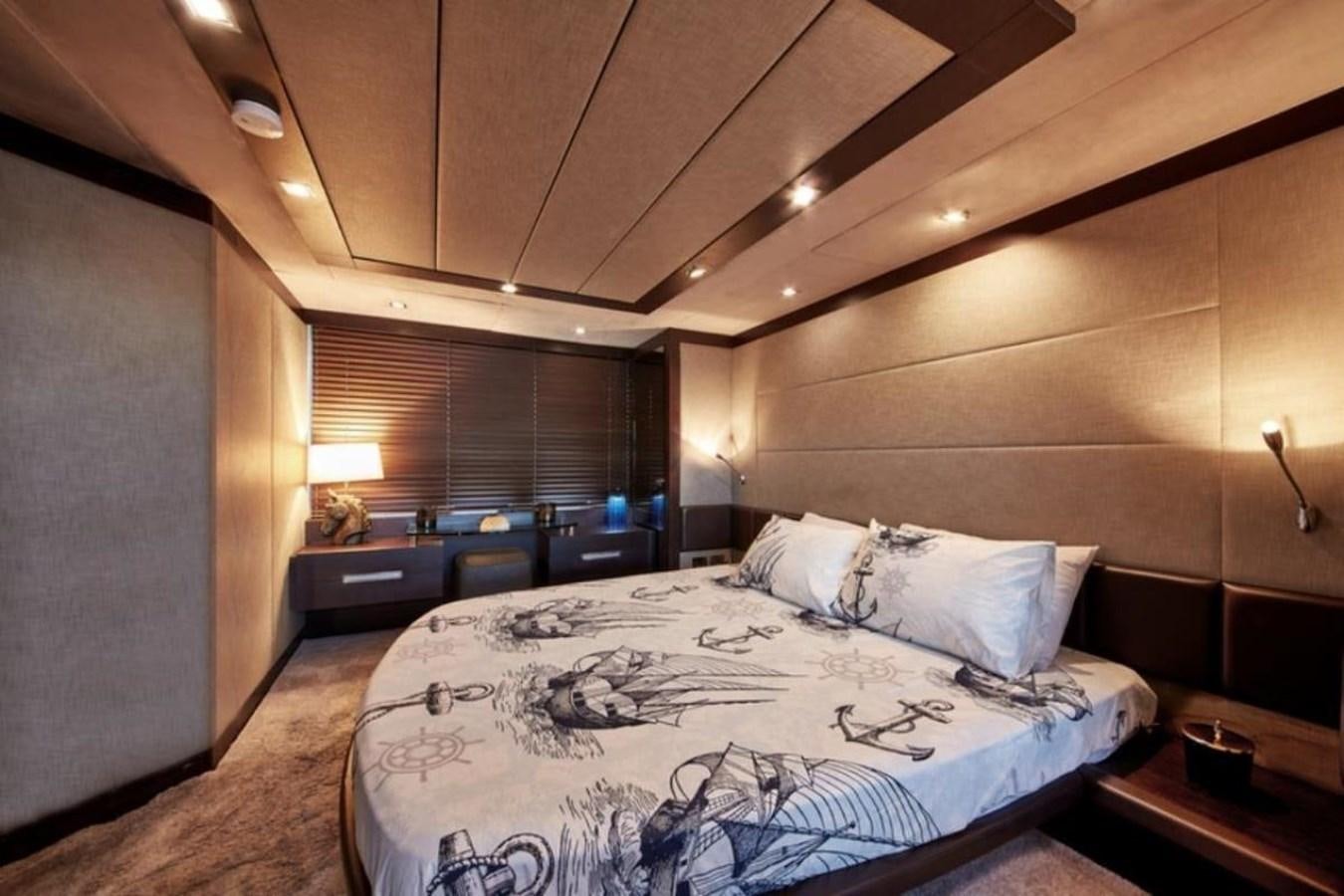 a bedroom with a bed and a desk aboard AZIMUT 98 Yacht for Sale