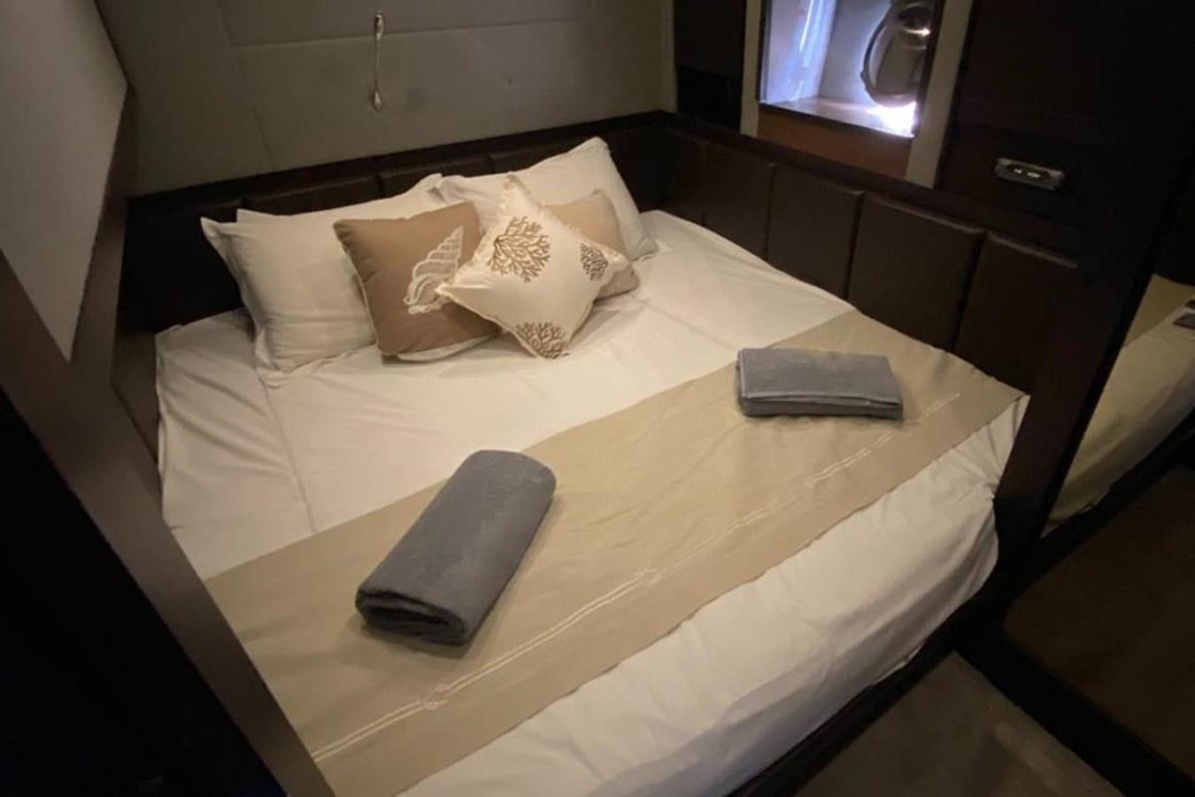 a bed with white sheets and pillows aboard AZIMUT 98 Yacht for Sale