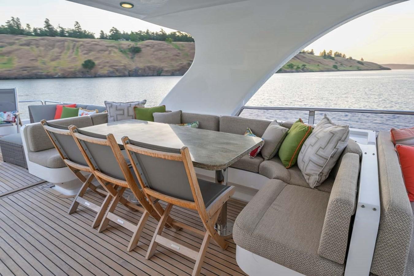 a deck with chairs and a table on it aboard BELLA SOGNO Yacht for Sale
