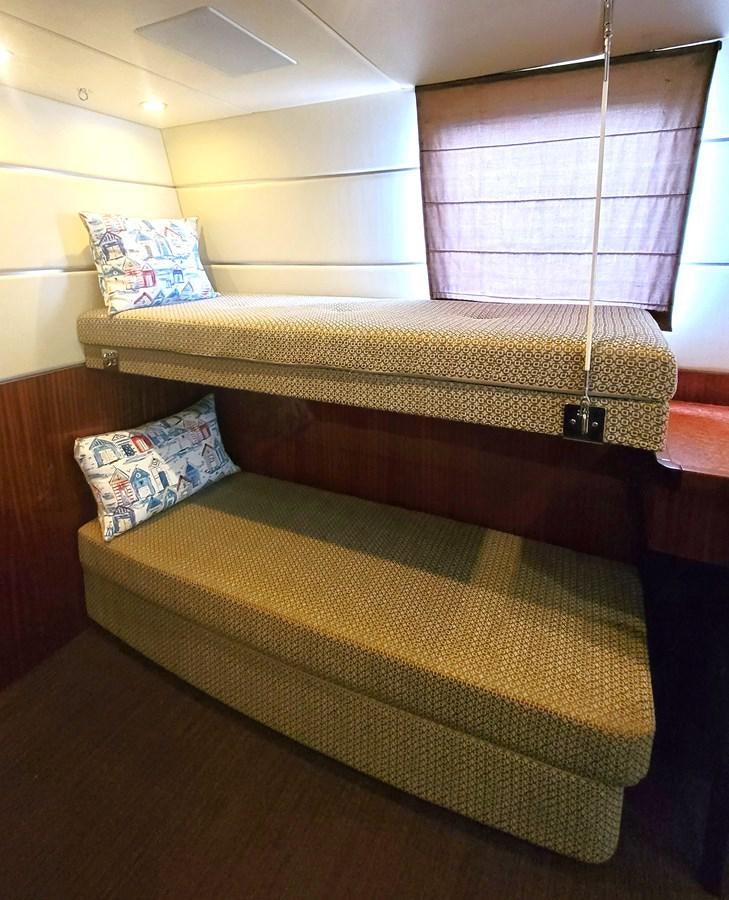 a bed with a yellow sheet aboard BELLA SOGNO Yacht for Sale