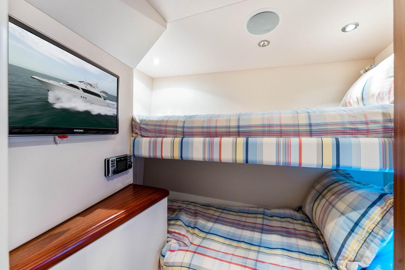 a room with a bed and a television aboard RUMOURS Yacht for Sale