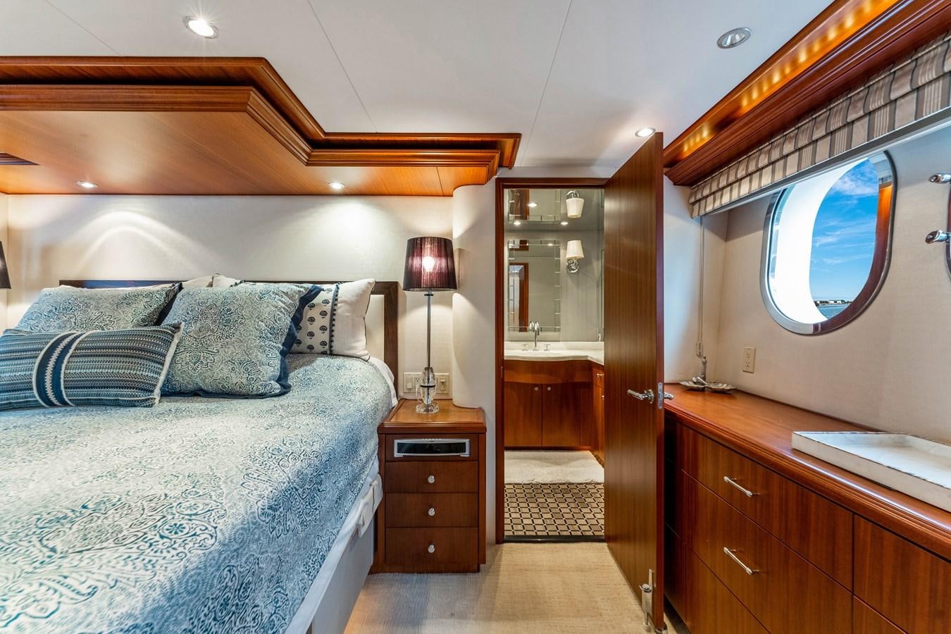 a bedroom with a bed and a mirror aboard RUMOURS Yacht for Sale