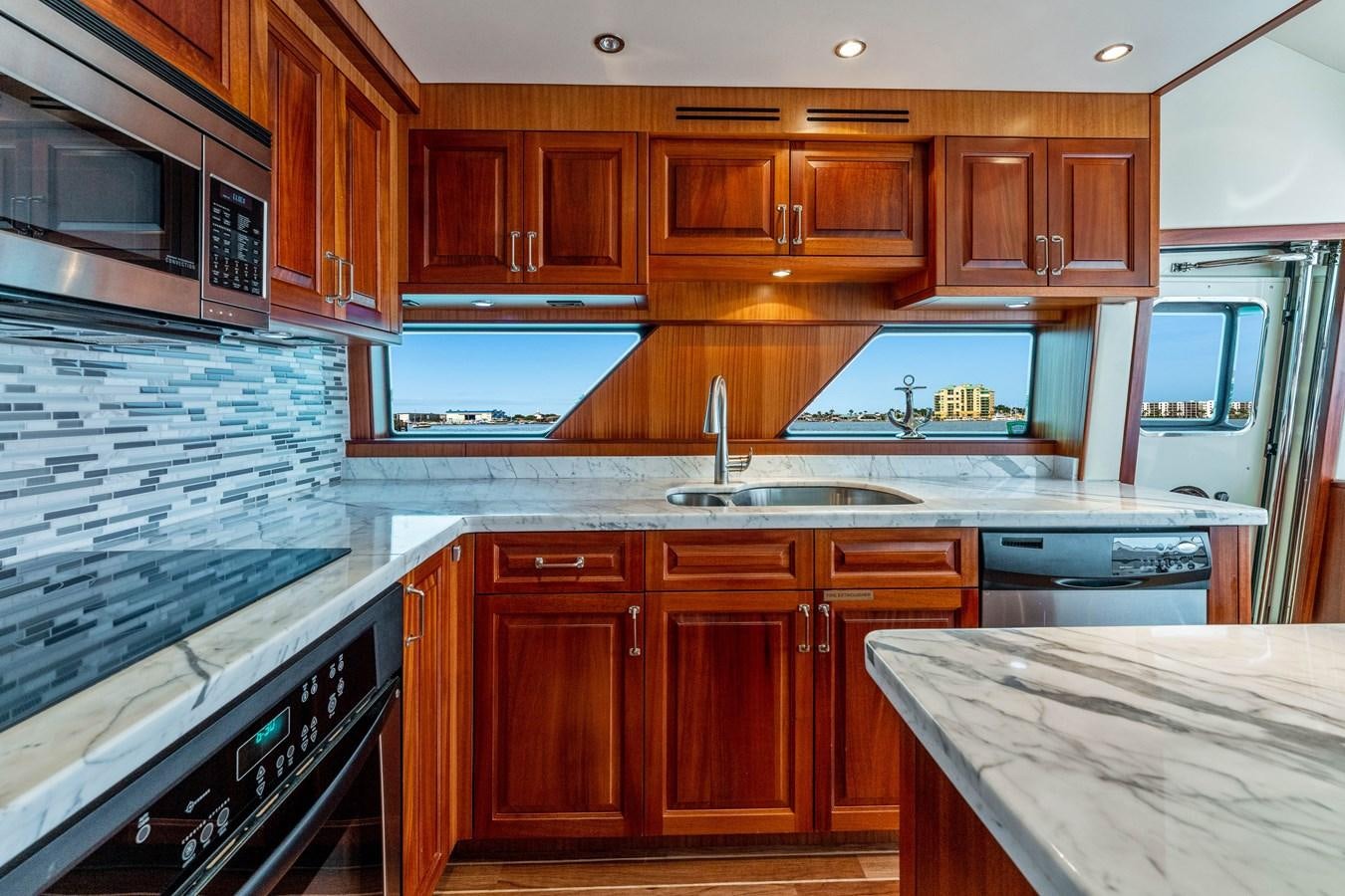 a kitchen with wooden cabinets aboard RUMOURS Yacht for Sale