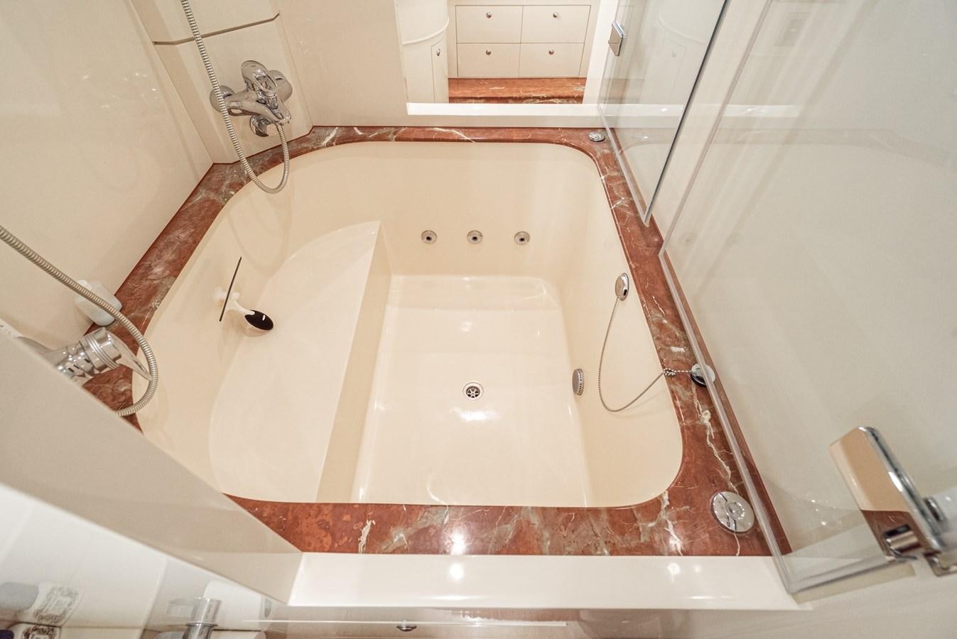 a bathtub with a shower head aboard LIBERTY Yacht for Sale