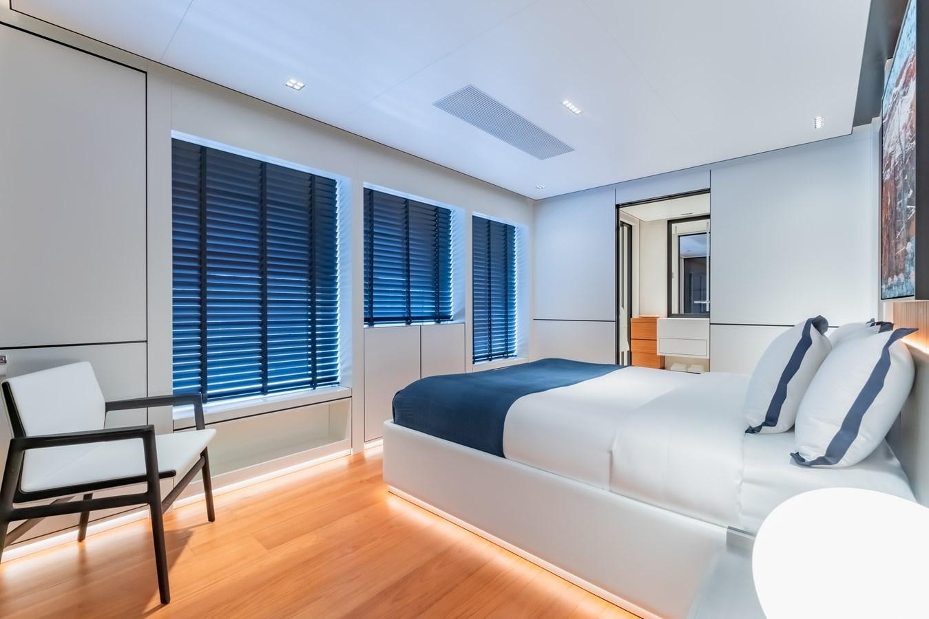 a bedroom with a bed and a chair aboard SPACECAT Yacht for Sale