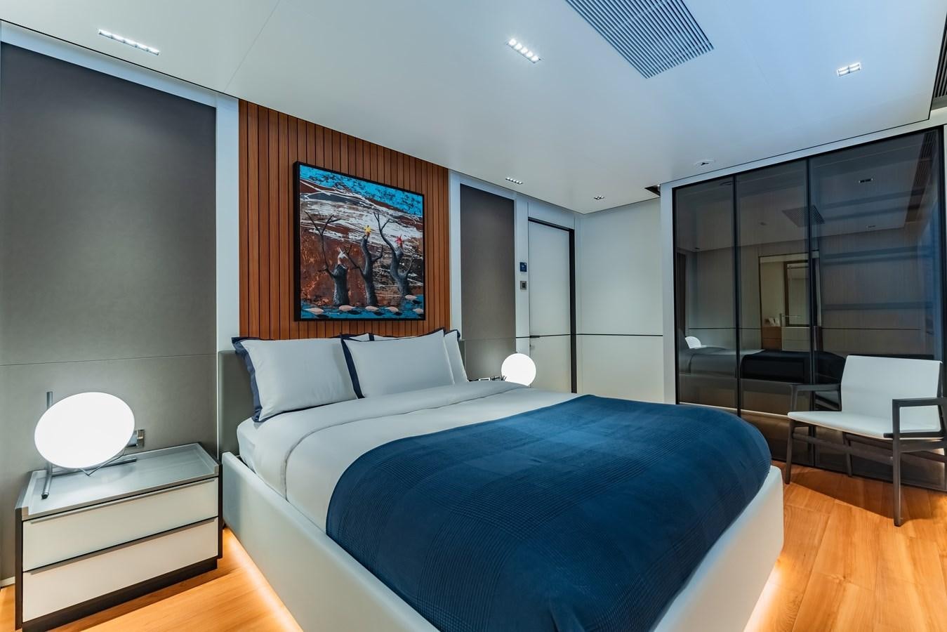 a bedroom with a bed and a desk aboard SPACECAT Yacht for Sale