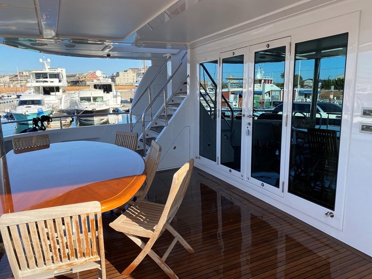 a balcony with a table and chairs aboard RICHESSE Yacht for Sale