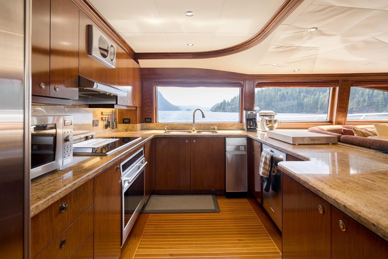 a kitchen with wooden cabinets aboard REPOSADO Yacht for Sale