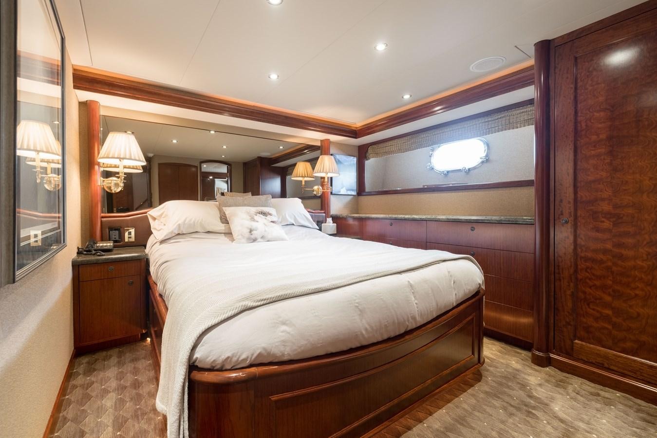 a bedroom with a bed and a mirror aboard REPOSADO Yacht for Sale