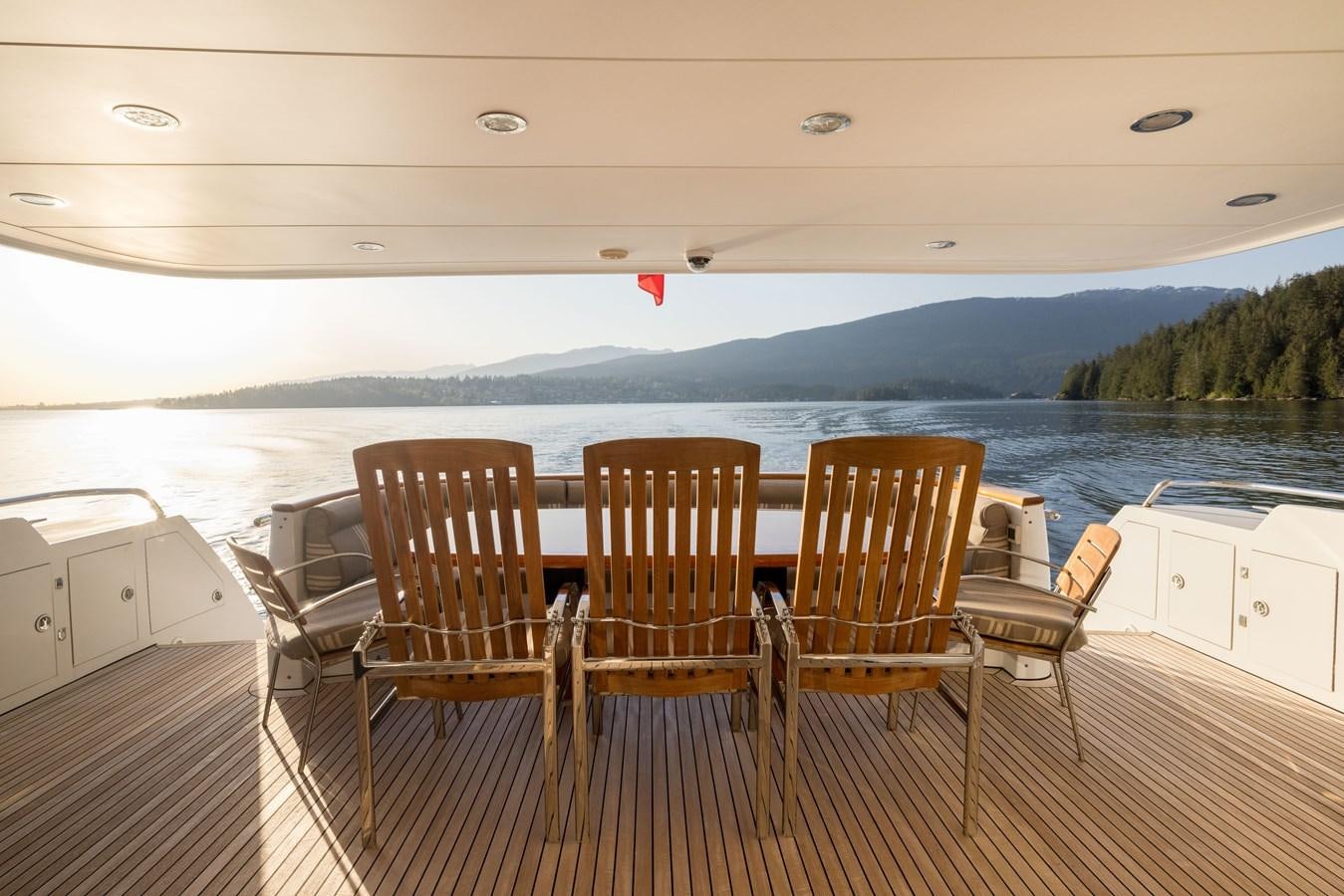 a deck with chairs and a body of water in the background aboard REPOSADO Yacht for Sale