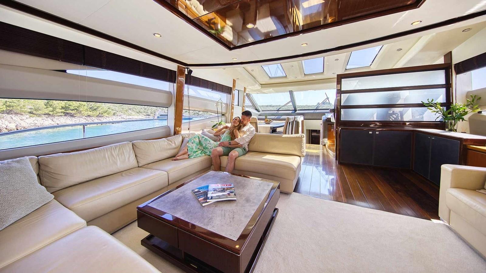 a man sitting on a couch with a woman sitting on a couch aboard AGAVE Yacht for Sale