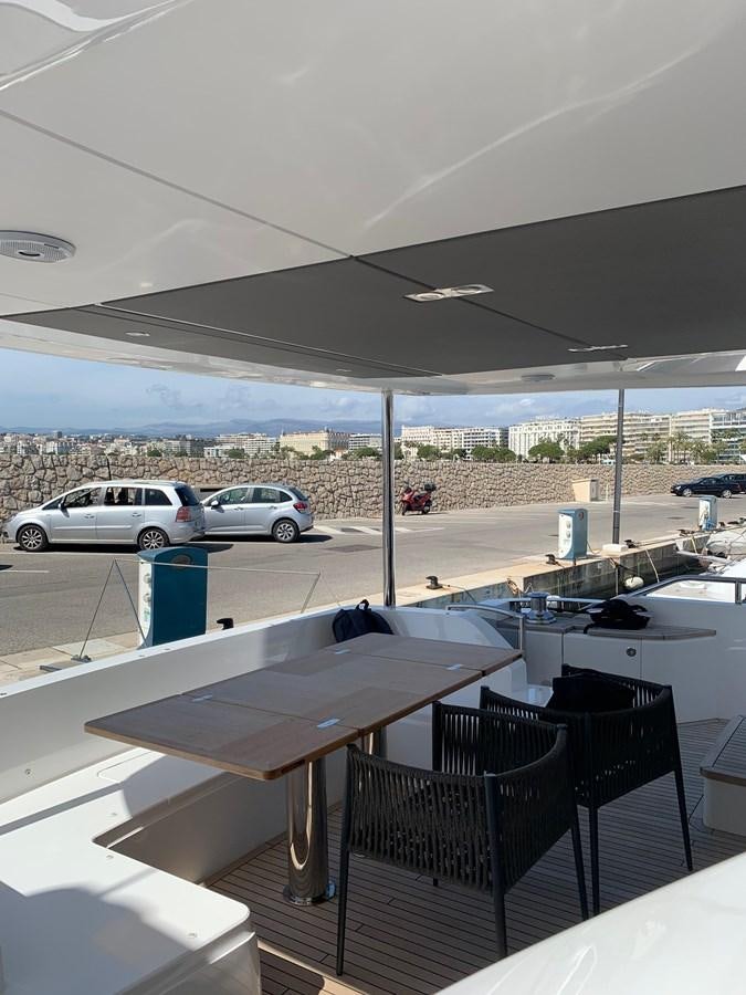 a table and chairs on a balcony aboard XM Yacht for Sale