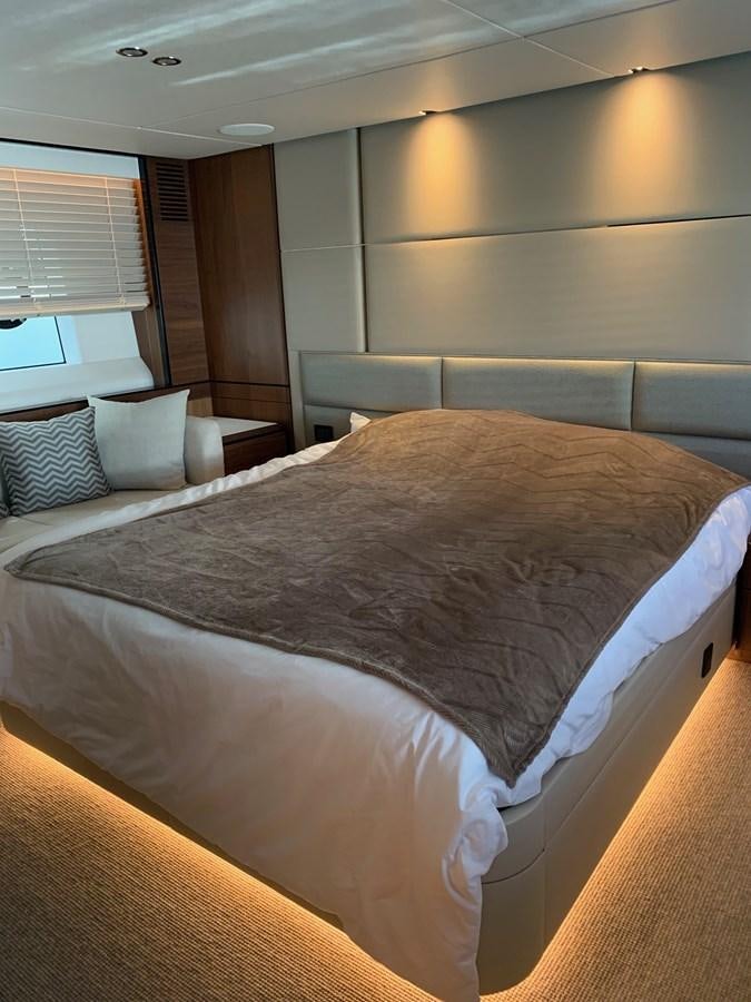 a bed with a white comforter aboard XM Yacht for Sale