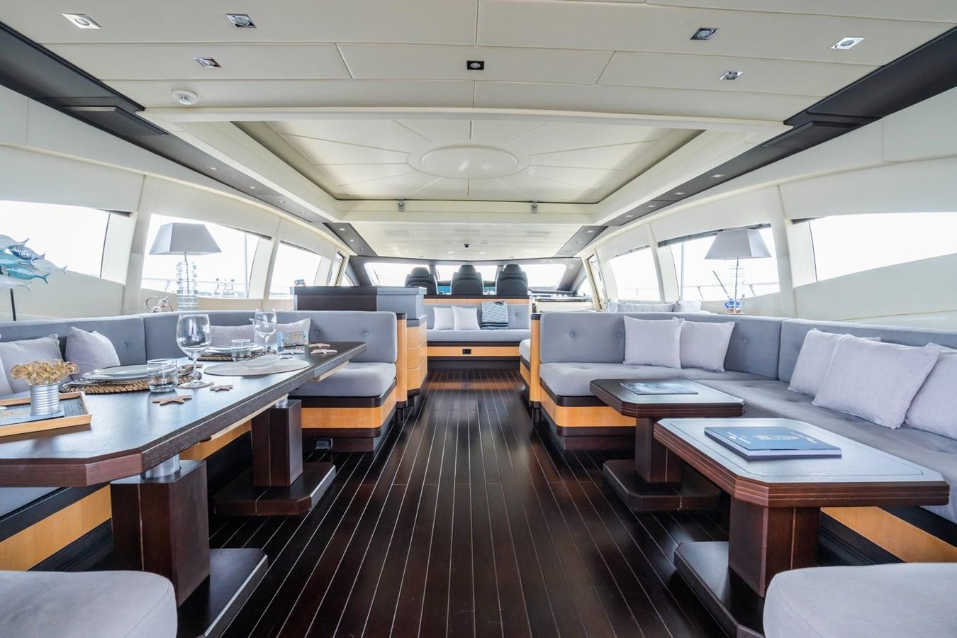 a room with a wood floor and a wood table with chairs and a large window with a wood aboard TECHNOMARINE Yacht for Sale