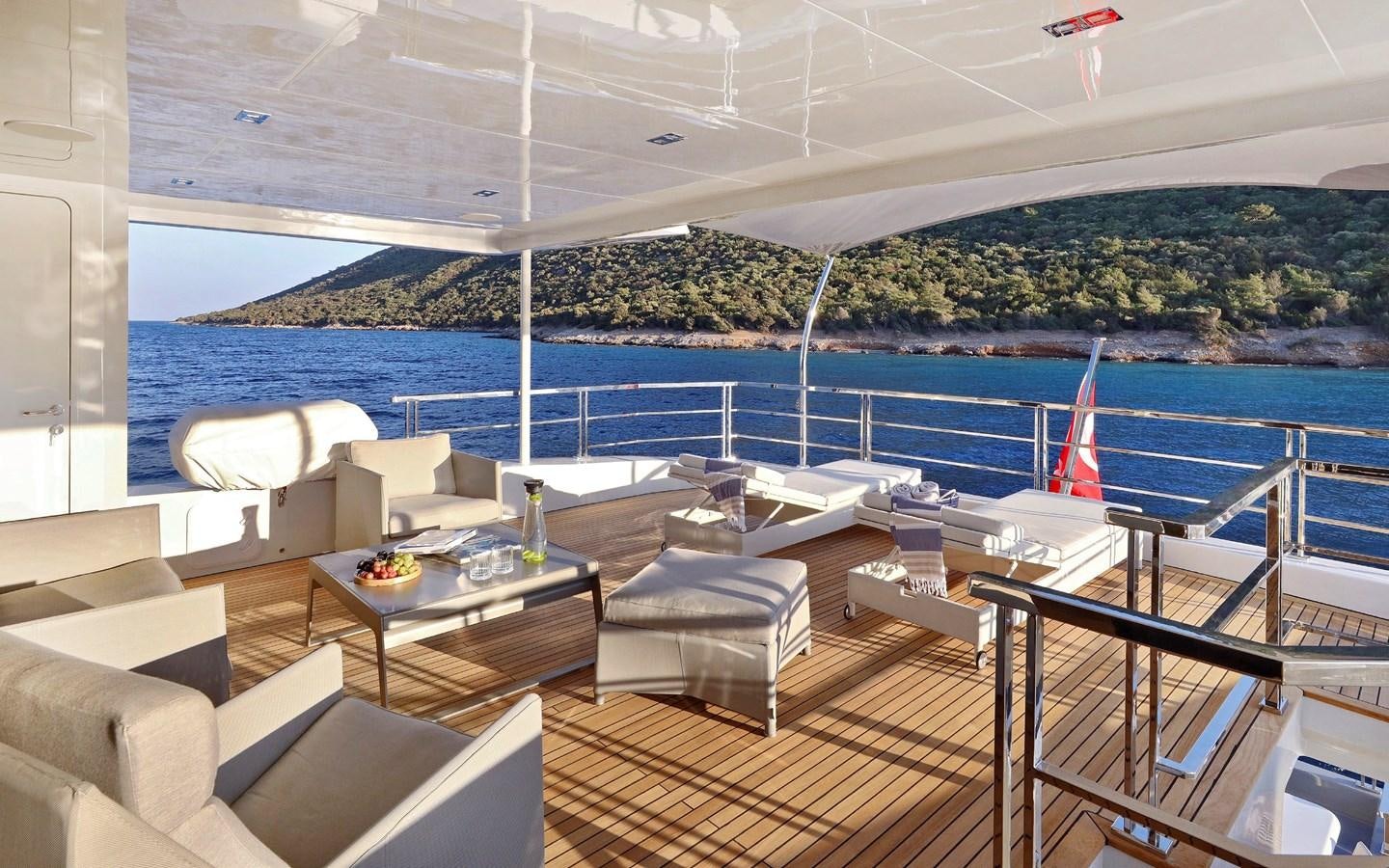 a lounge area with a pool and a deck with chairs and a beach aboard AEGEAN EXPLORER 26M/02 Yacht for Sale