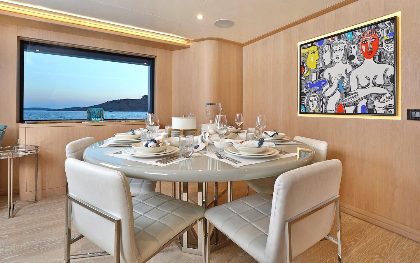 a table with a white chair and a television on the wall aboard AEGEAN EXPLORER 26M/02 Yacht for Sale