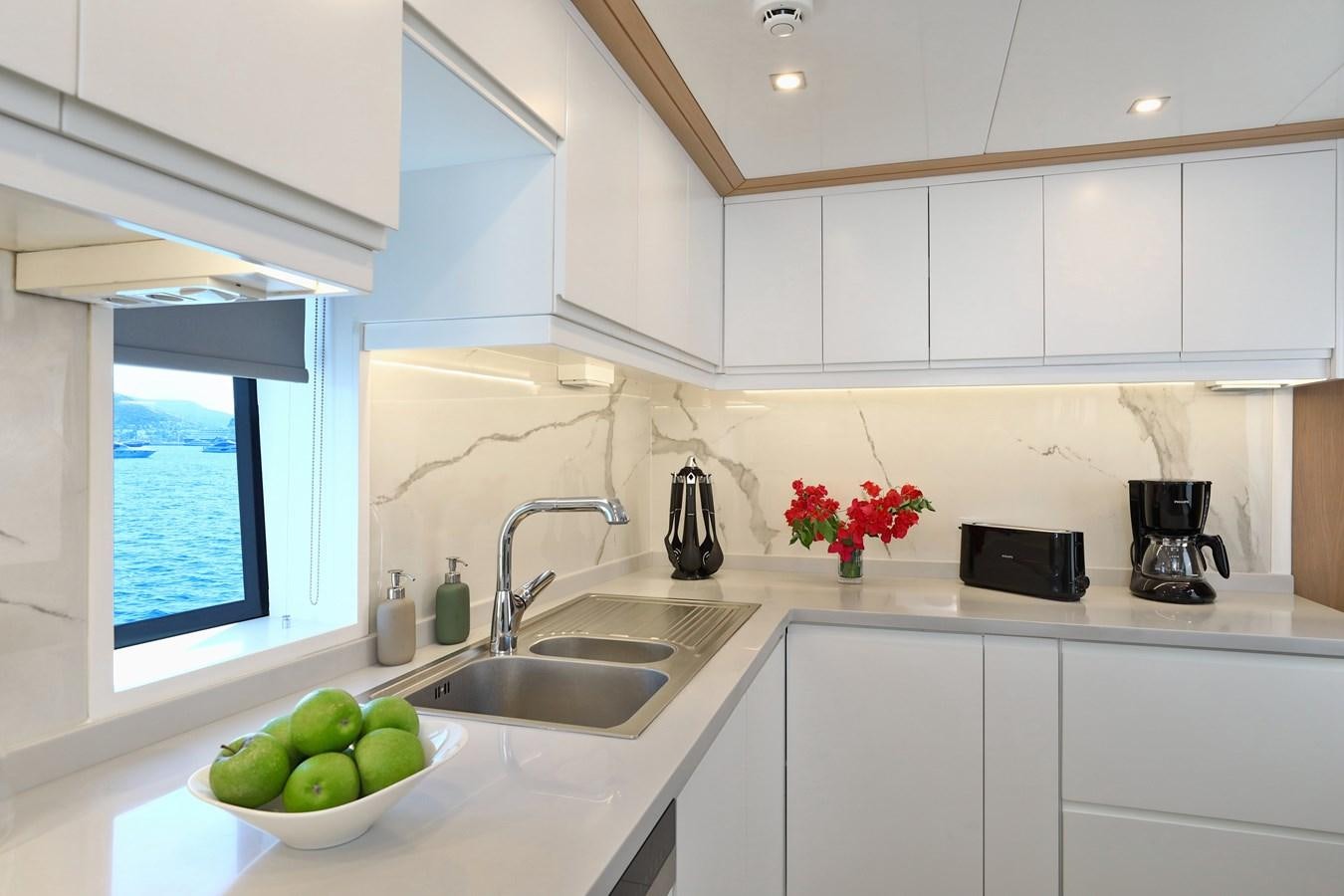 a kitchen with white cabinets aboard AEGEAN EXPLORER 26M/02 Yacht for Sale