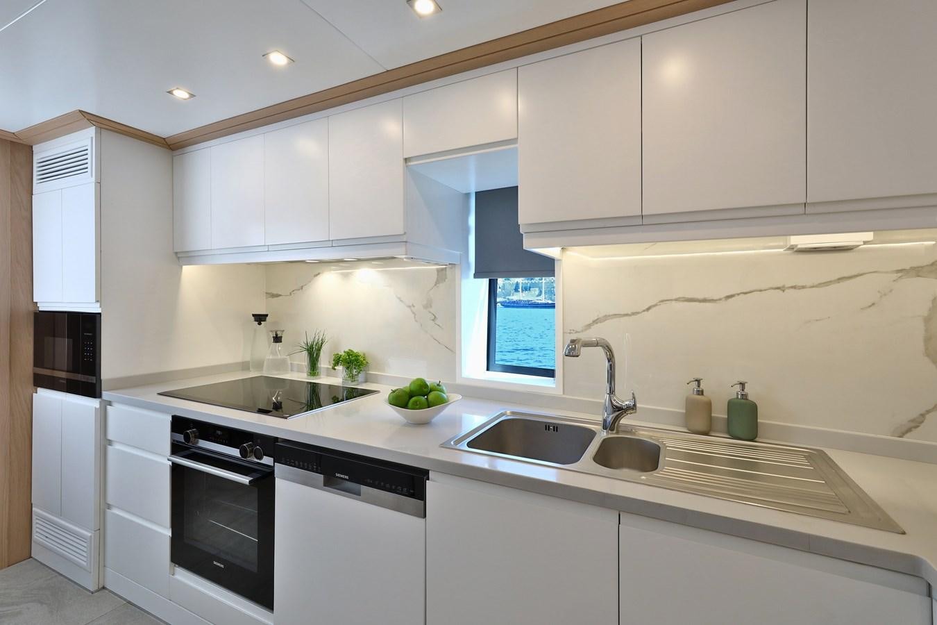 a kitchen with white cabinets aboard AEGEAN EXPLORER 26M/02 Yacht for Sale