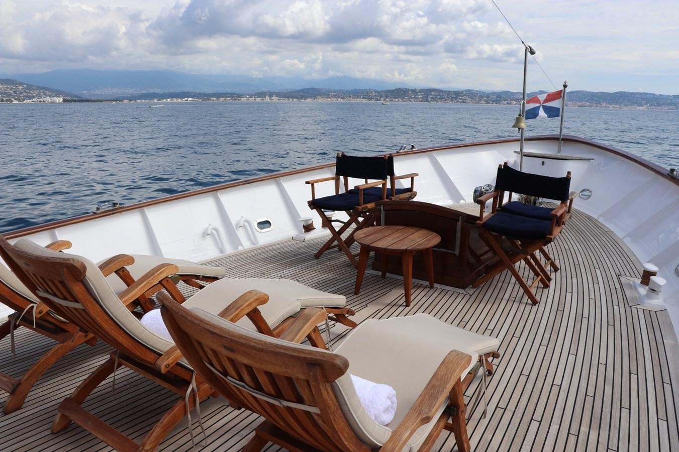 a deck with chairs and a flag on it aboard SEALORD Yacht for Sale