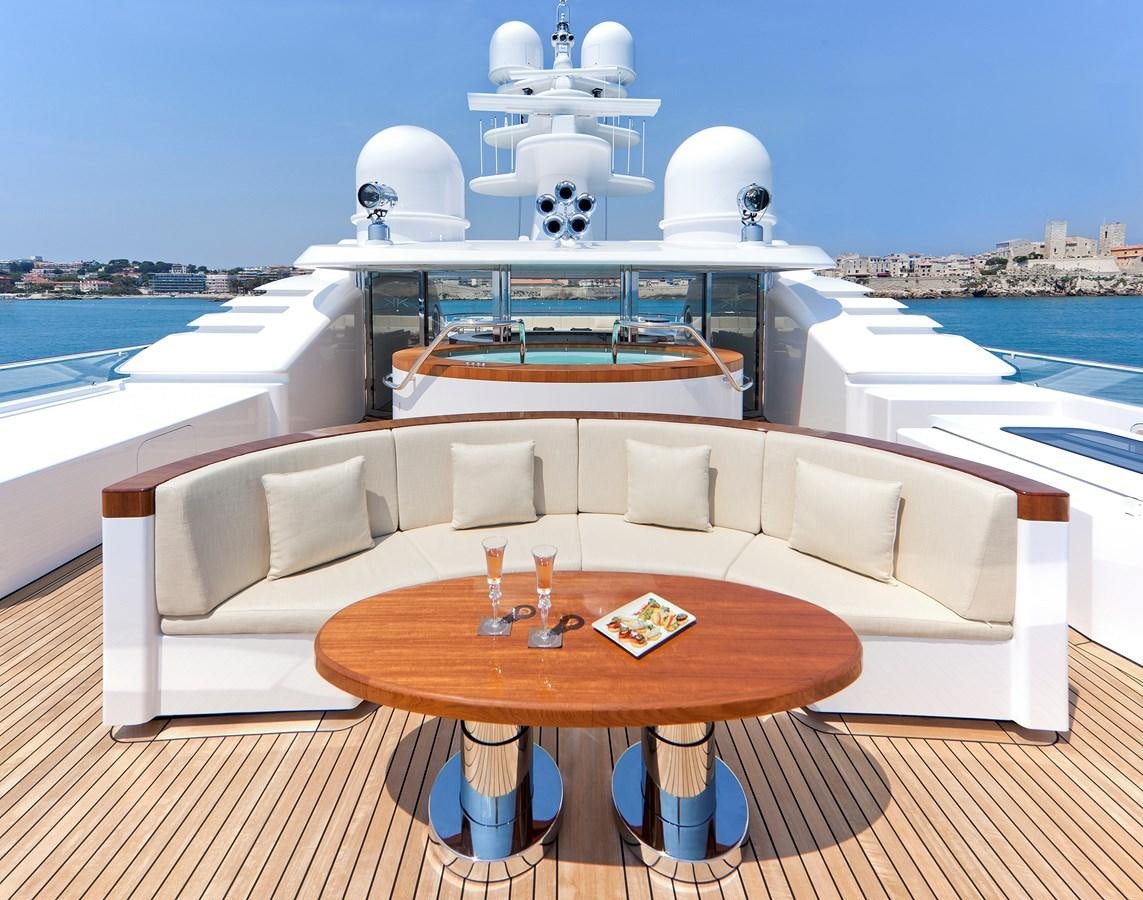a table on a deck overlooking a body of water aboard KAHALANI Yacht for Sale