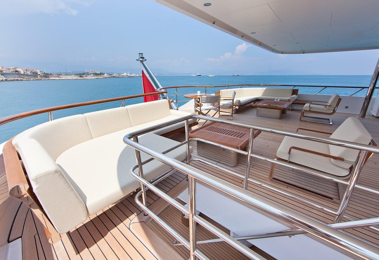 a deck with chairs and a flag on it aboard KAHALANI Yacht for Sale