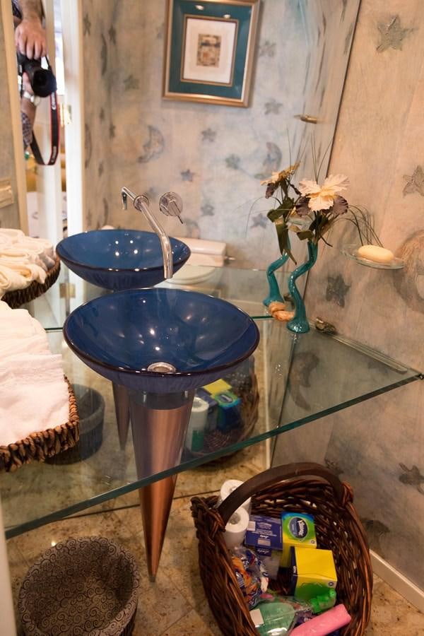 a sink and a basket with a bucket and a mirror aboard TAMTEEN Yacht for Sale