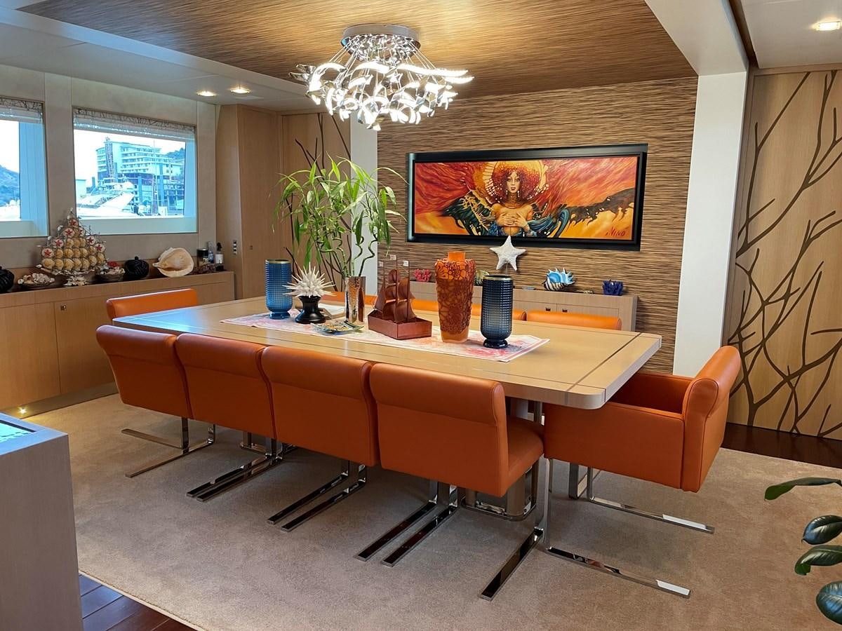 a large room with orange chairs and a table with a vase on it aboard ESPRESSO Yacht for Sale