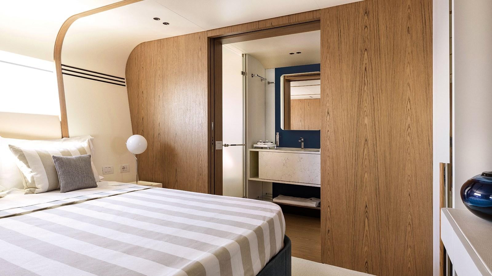 a room with a bed and a wood door aboard KOJU Yacht for Sale
