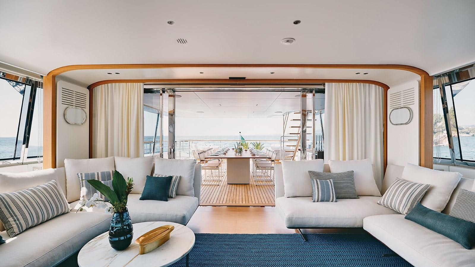 a living room with a large balcony aboard KOJU Yacht for Sale