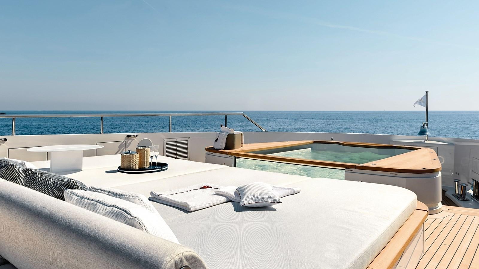 a bed on a balcony overlooking the ocean aboard KOJU Yacht for Sale