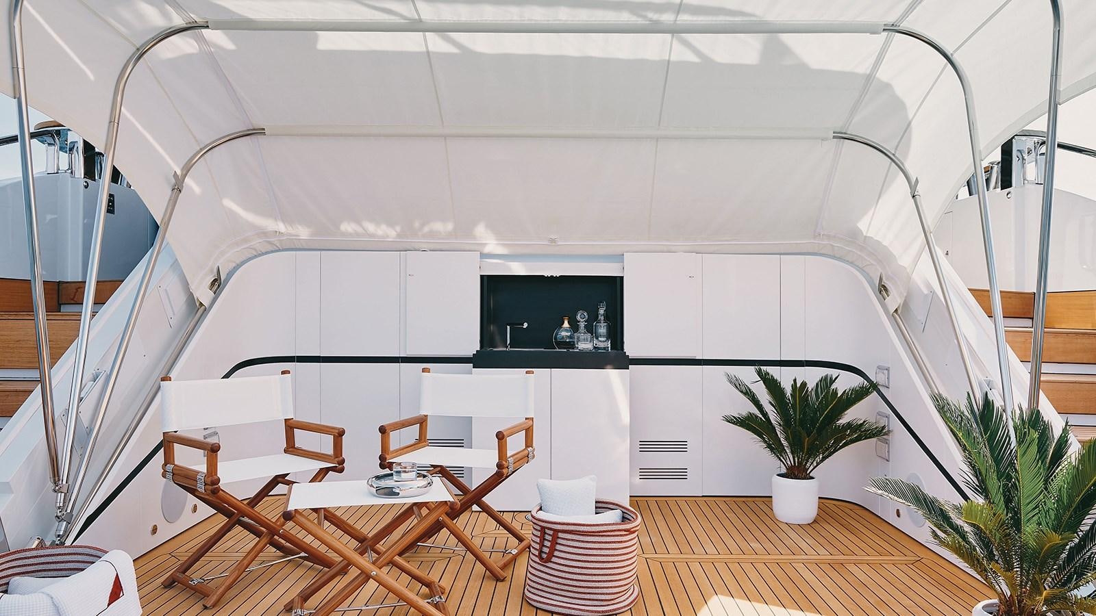 a room with tables and chairs aboard KOJU Yacht for Sale