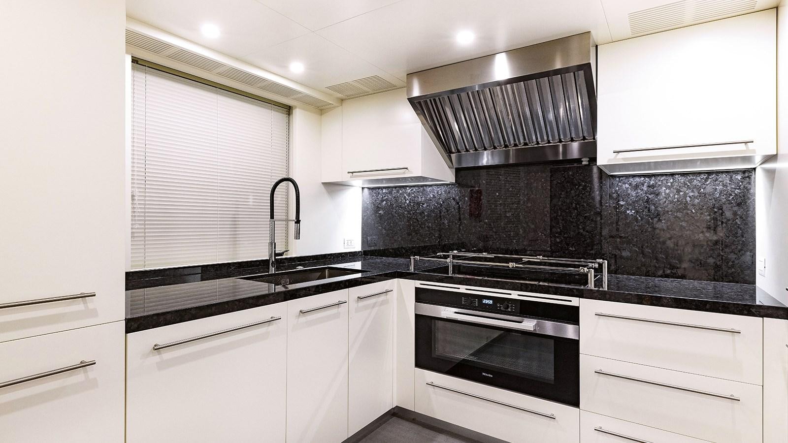 a kitchen with white cabinets aboard KOJU Yacht for Sale