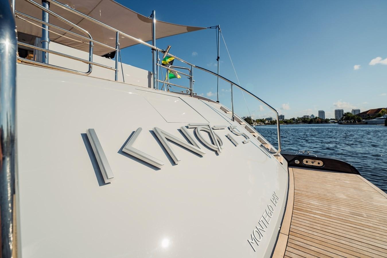 a white boat on a body of water aboard 7 KNOTS Yacht for Sale