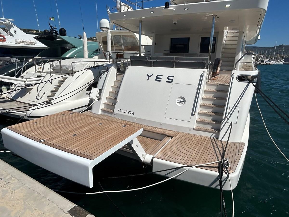 a boat docked at a pier aboard YES Yacht for Sale