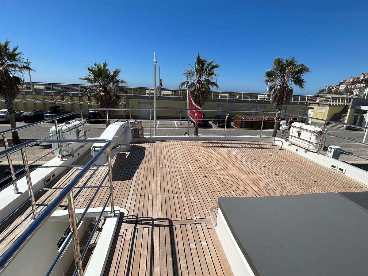 a deck with a deck and a flag on it aboard YES Yacht for Sale