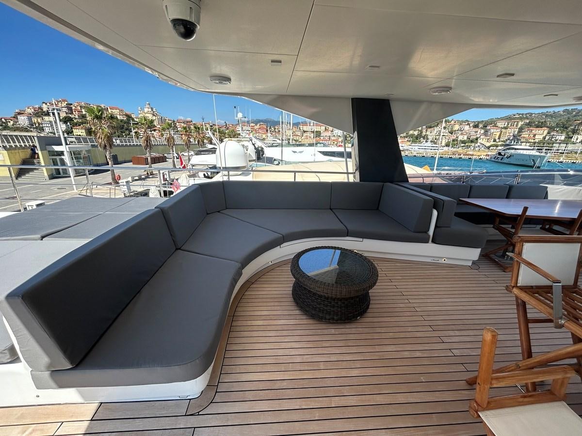 a deck with a large pool and a deck with chairs and tables aboard YES Yacht for Sale