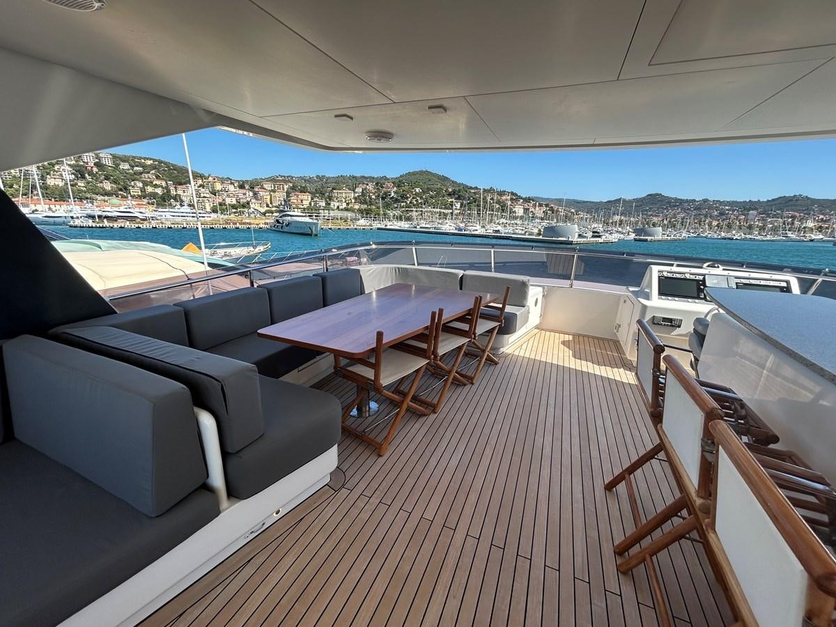 a deck with a table and chairs on it aboard YES Yacht for Sale