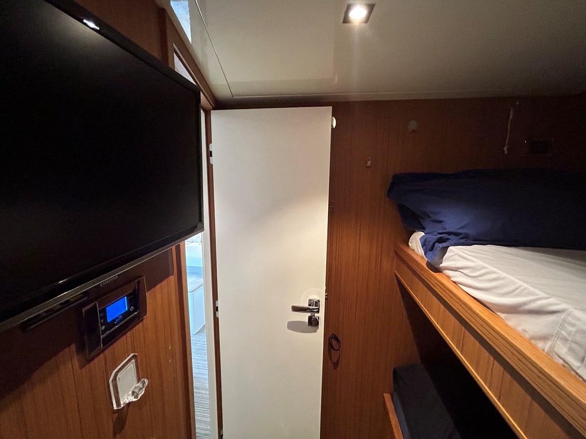 a room with a bed and a television aboard YES Yacht for Sale