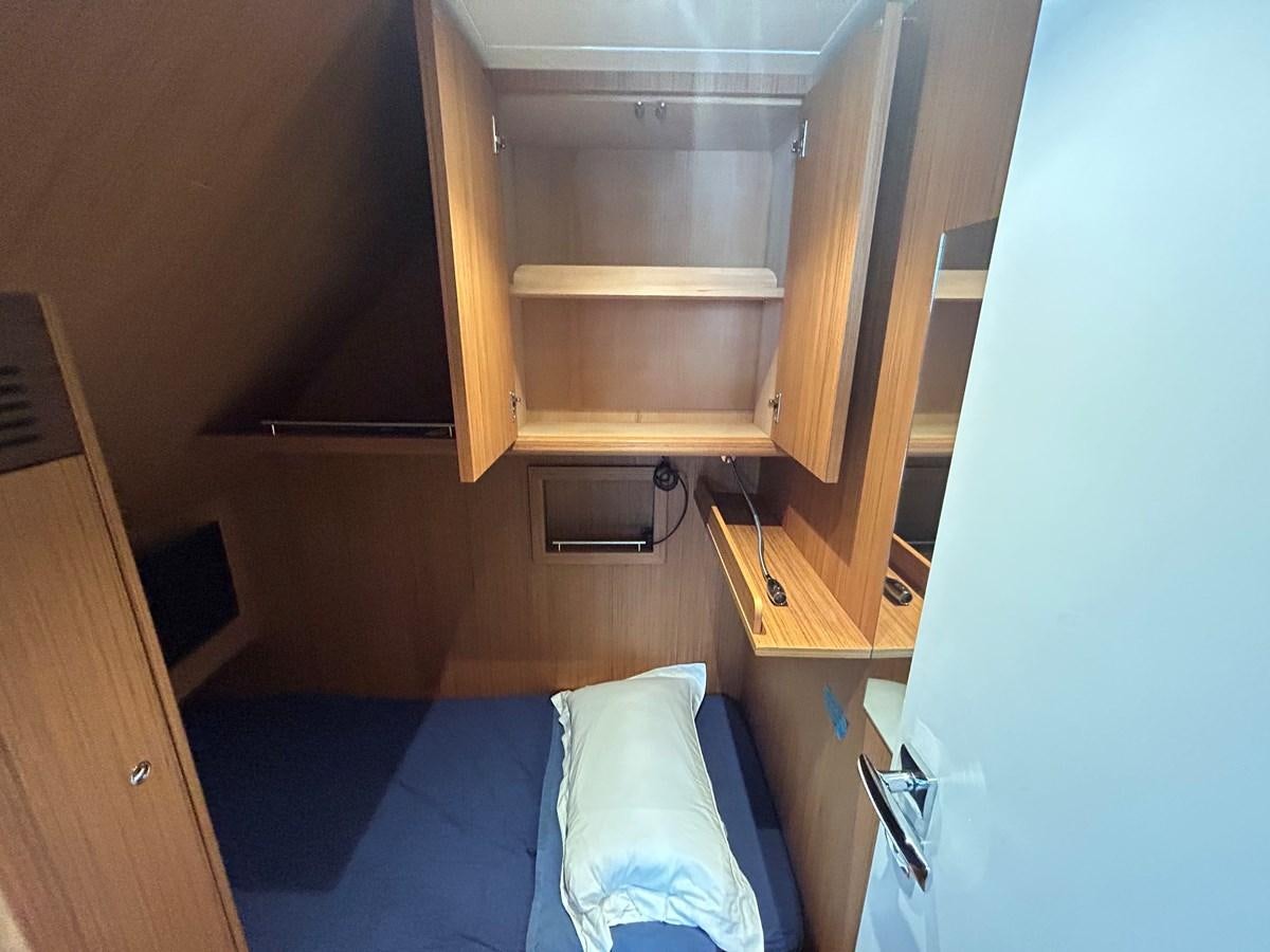 a room with a bed and a shelf aboard YES Yacht for Sale