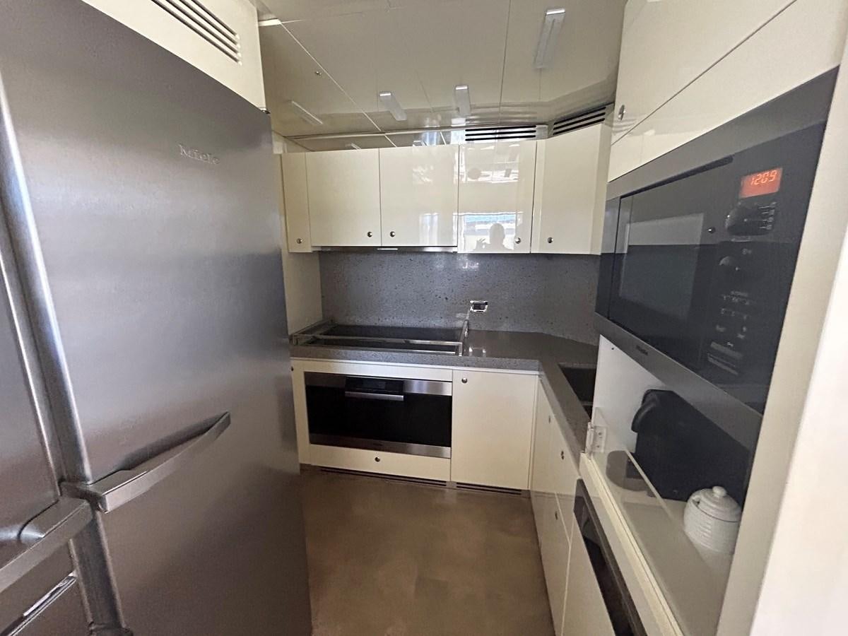 a kitchen with white cabinets aboard YES Yacht for Sale