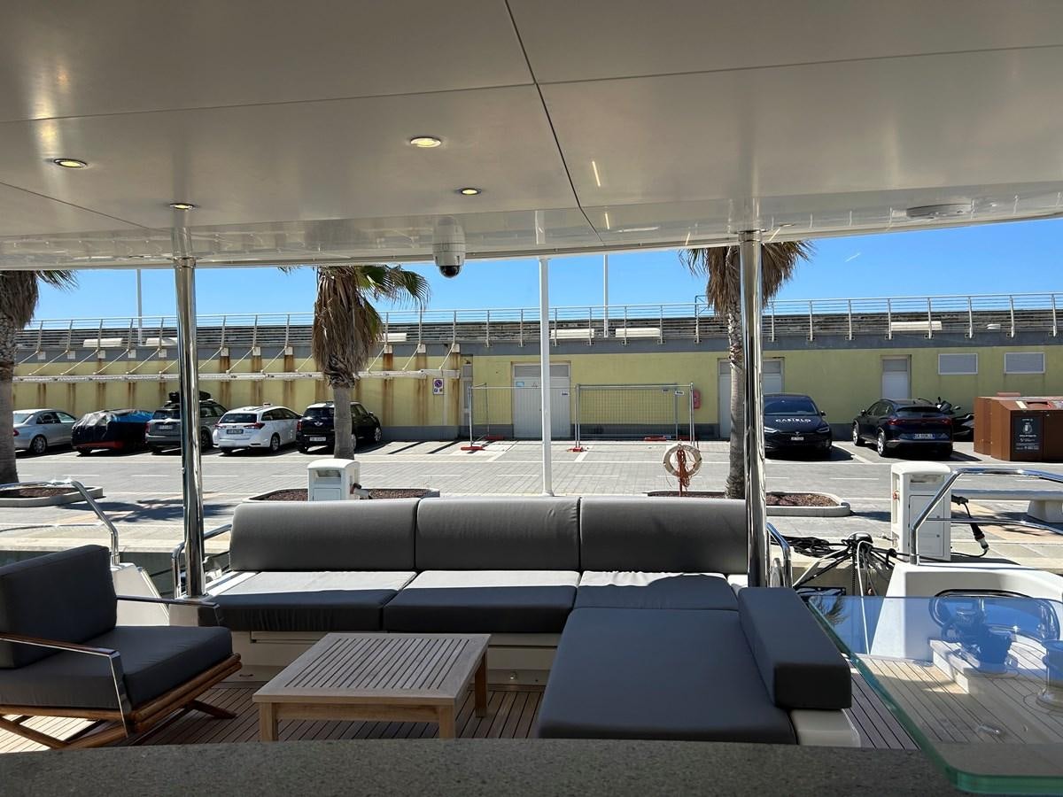 a room with a large window and a couch and a table with chairs aboard YES Yacht for Sale